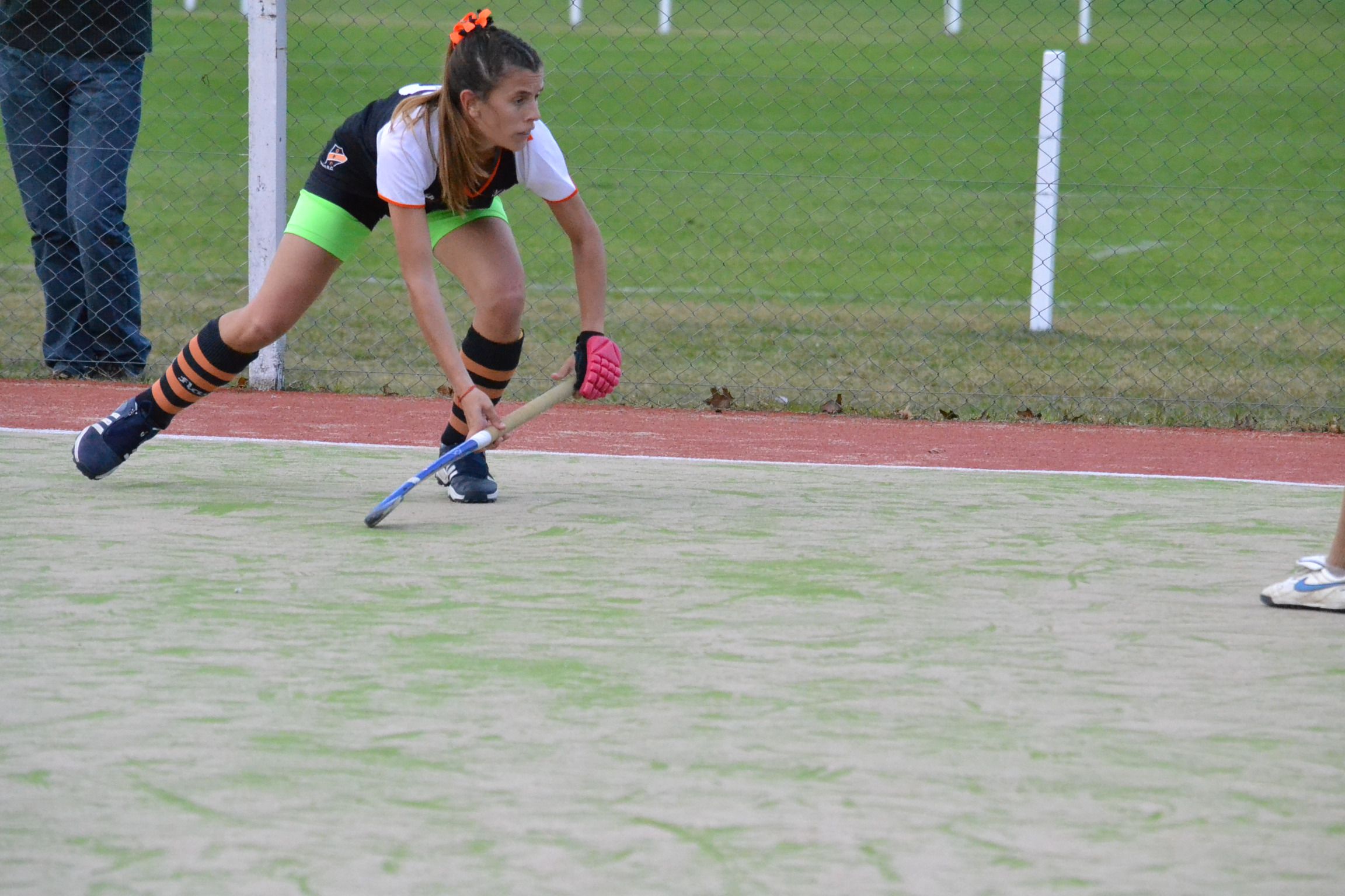 Jugadora de hockey de Olivos conduciendo la bocha en la cancha