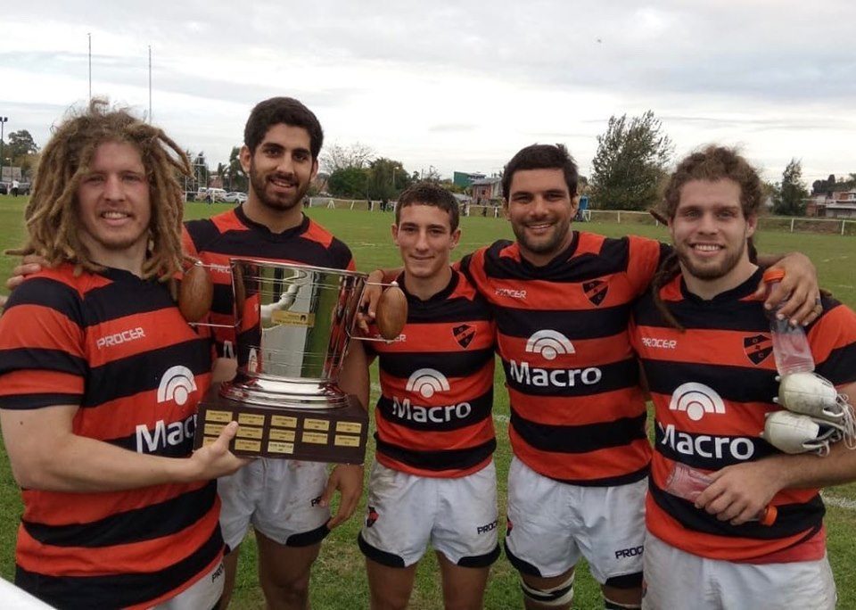Jugadores de Olivos con un trofeo en la cancha del club